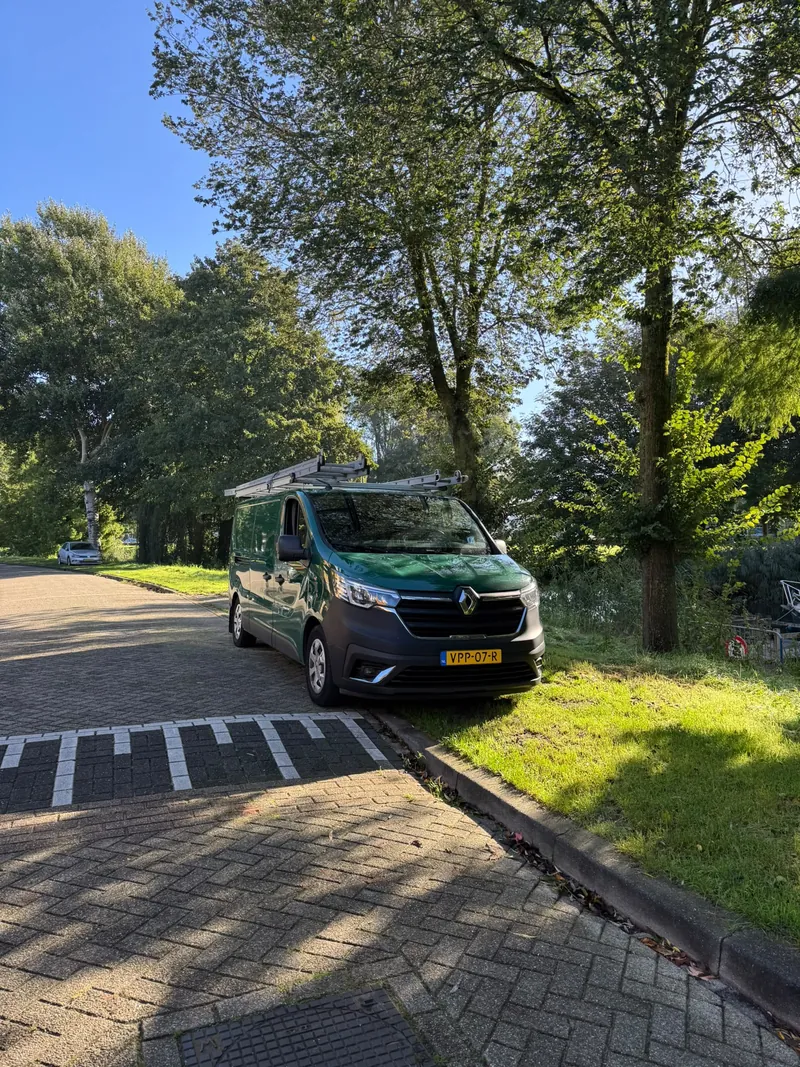 Bedrijfsbus van 36 Multidiensten langs een laan met bomen