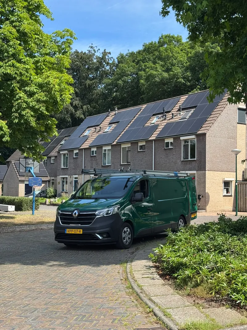 Bedrijfsbus van 36 Multidiensten geparkeerd voor een rij woningen