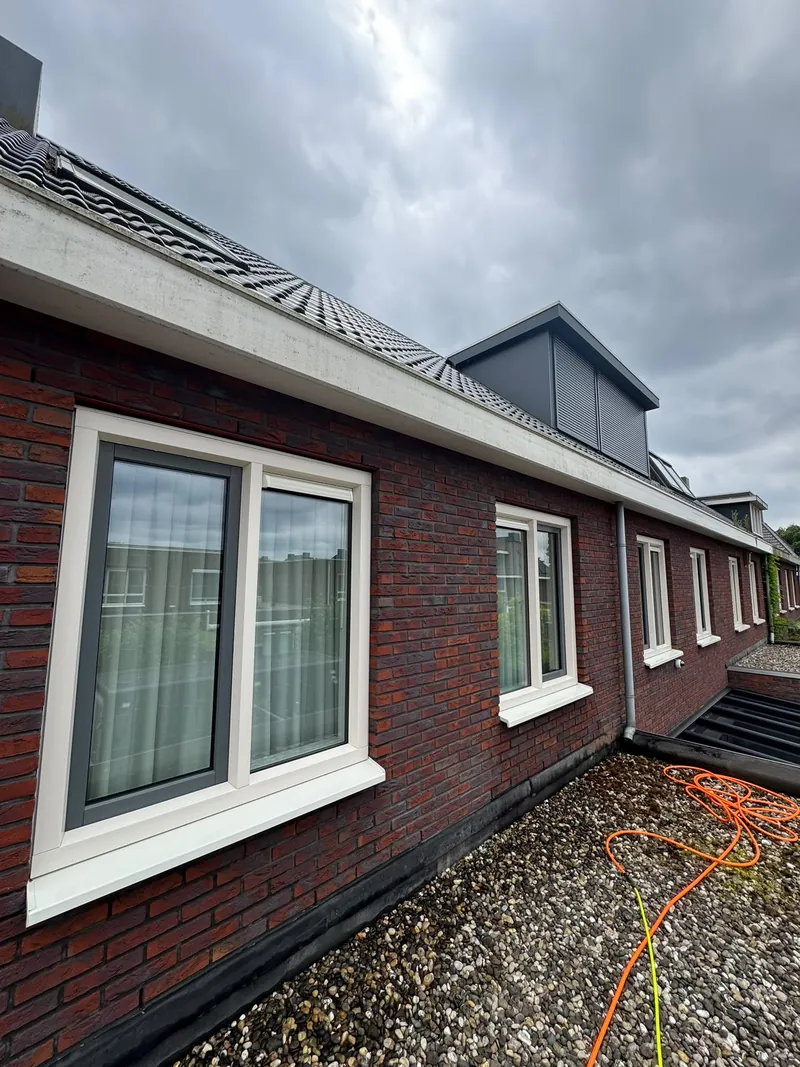 Gereinigde gevel van een woning met witte kozijnen